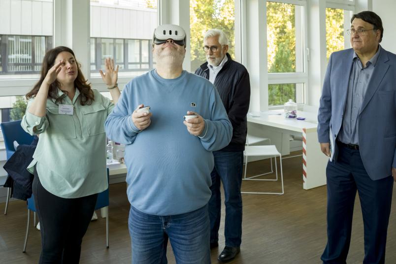 Ein Mann mit einer VR-Brille, umgeben von anderen Personen