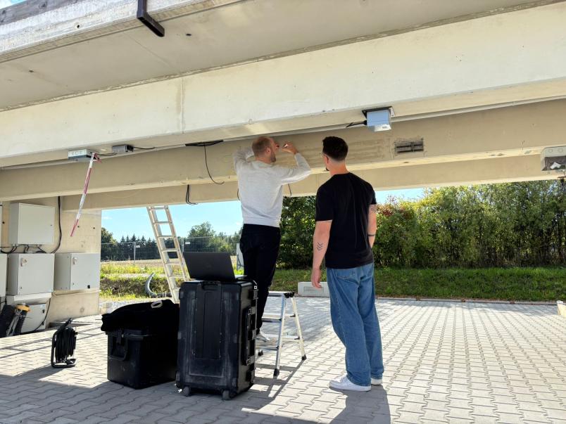 Zwei Männer stehen unter einer Brücke und bringt etwas an