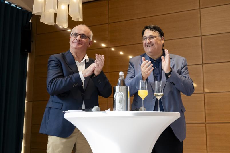 Manfred Bayer und Martin Paul klatschend an einem Stehtisch