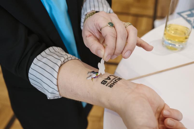 Ein Einhorn-Tattoo wird auf einen Arm geklebt