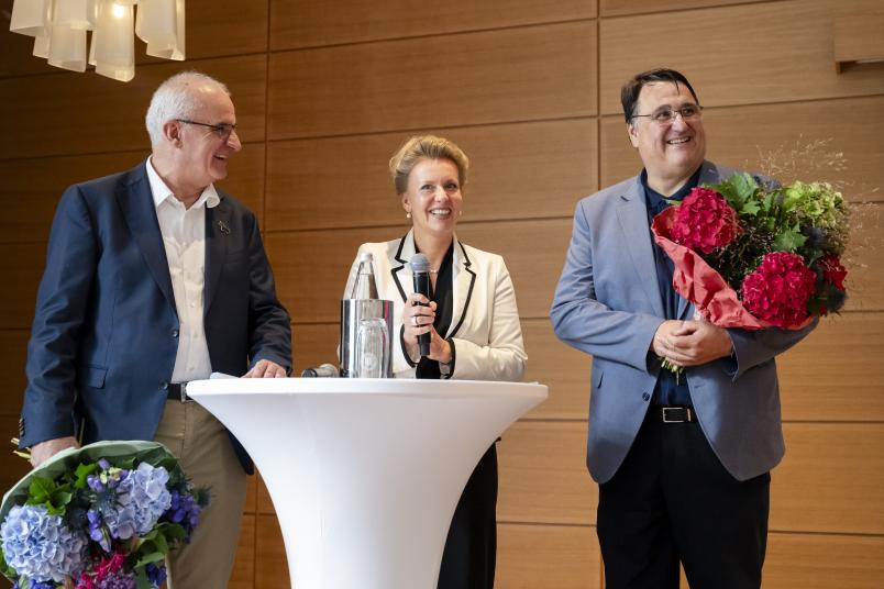 Drei Menschen an einem Stehtisch