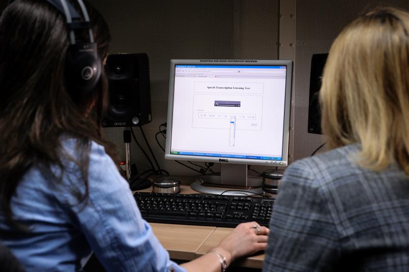 Zwei Frauen schauen auf einen Computerbildschirm.