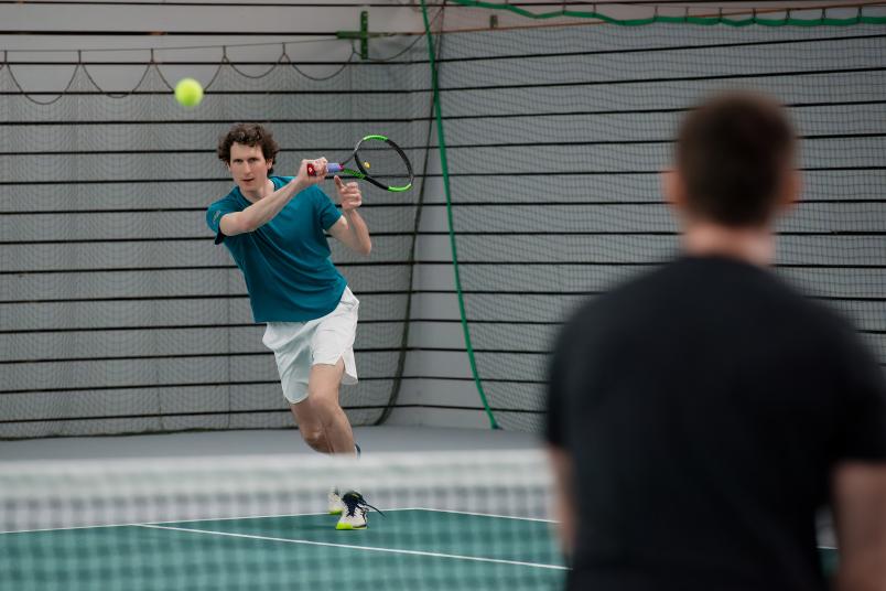 Ein Tennisspieler läuft dem Ball entgegen.