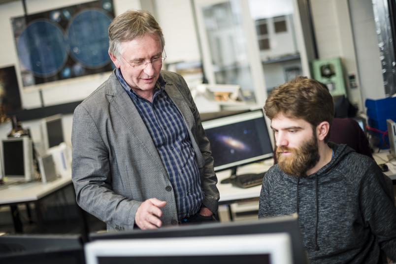 Zwei Männer diskutieren vor einem Bildschirm