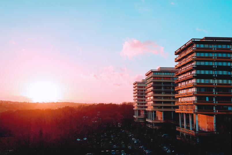 Foto von einer roten Sonne, die hinter dem Campus aufgeht.