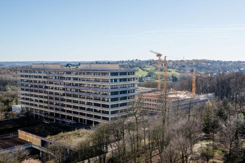 Seitenansicht des Gebäudes GC. Es ist ein sonniger Wintertag. Am angrenzenden Gebäude GD stehen Baukräne.