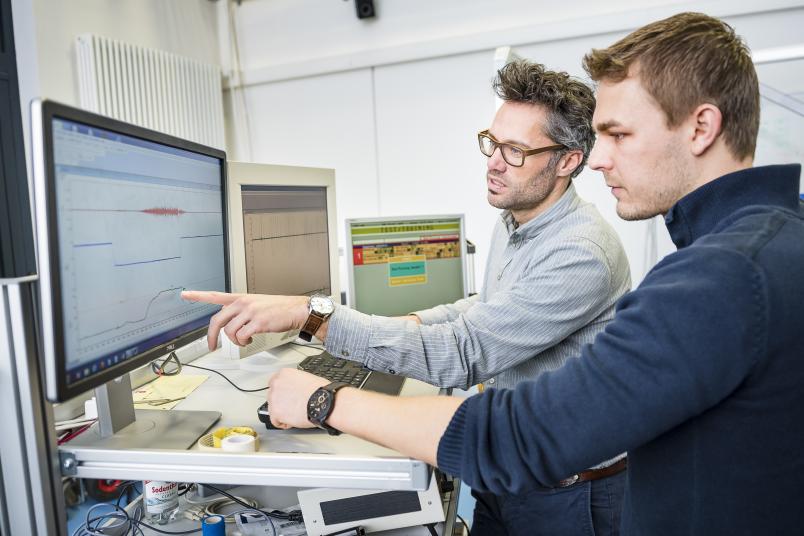 Forscher im Gespräch vor dem Monitor