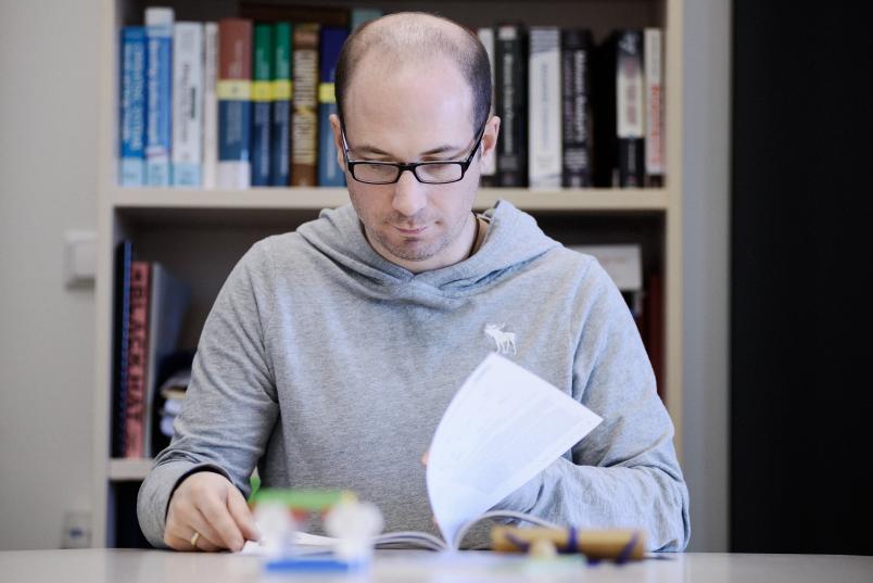 Forscher Thorsten Holz blättert ein einem Buch.