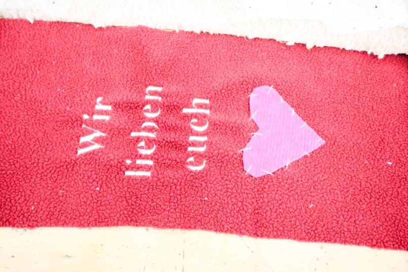 Stoffrest mit Aufschrift "Wir lieben euch"