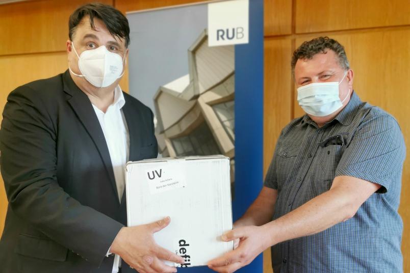 Mitte Juli 2022 hat Rektor Paul seinem Kollegen von der Universität Kiew, Volodymyr Bugrov (rechts), zwei Defibrillatoren überreicht.