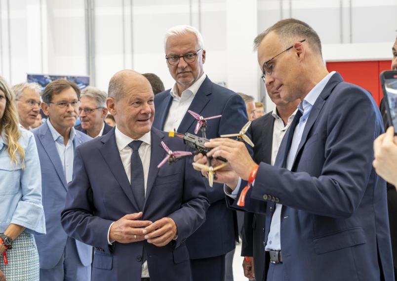 Prof. Dr. Martin Mönnigmann (rechts) zeigt dem Regionaldirektor und dem Bundeskanzler eine Drohne. Links neben Olaf Scholz im Bild zu sehen ist Dr. Frank Dudda, Vorsitzender der Verbandsversammlung des RVR.