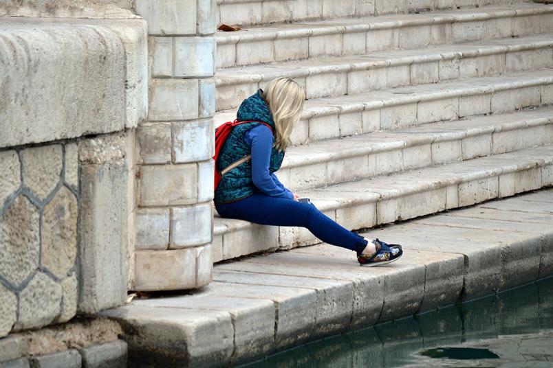 Frau sitzt auf einer Treppe