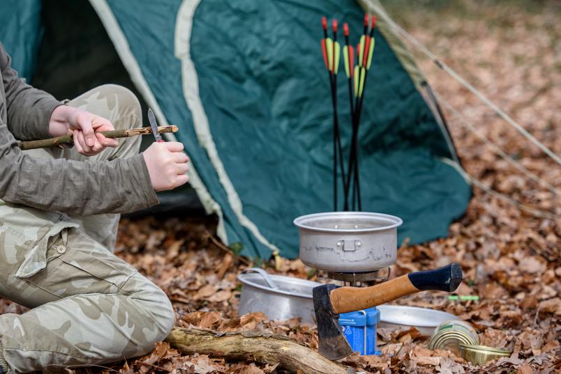 Zelt im Wald mit Axt