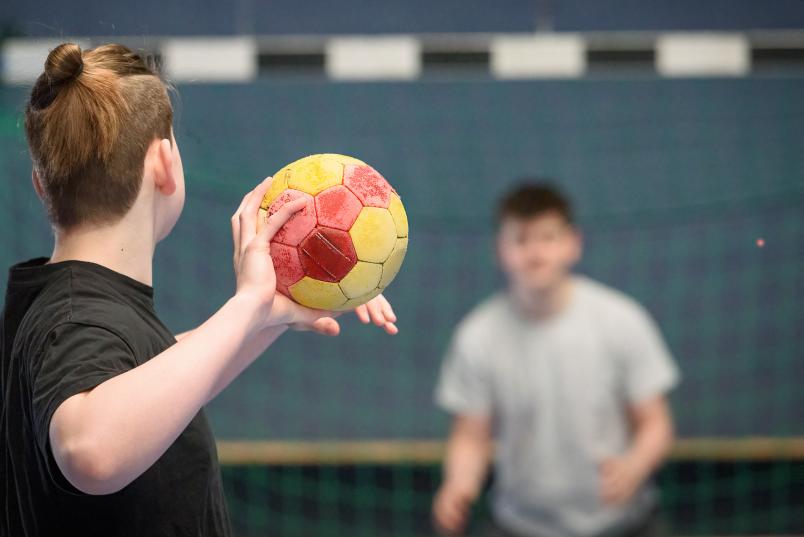 Schüler spielen sich Ball zu