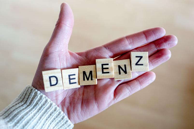 Buchstabenwürfel auf einer Hand, die das Wort "Demenz" bilden