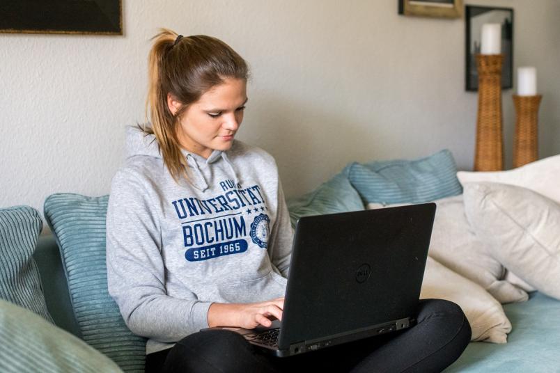 Studentin mit Laptop auf dem Schoß