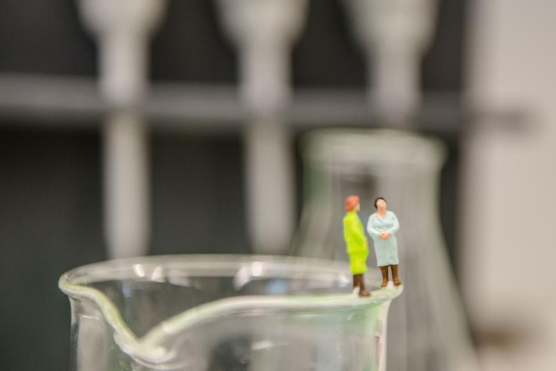 Zwei Minifiguren auf dem Rand eines Becherglases