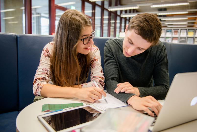 Zwei Studierende sitzen nebeneinander.