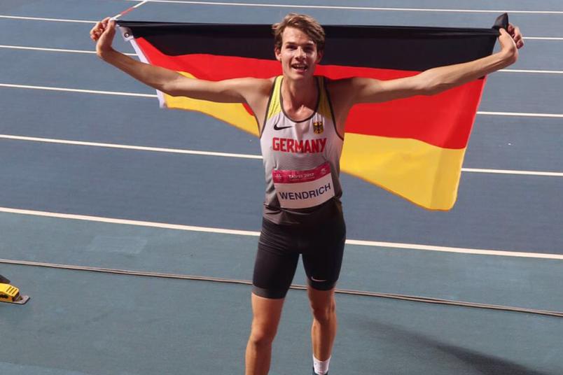 Ein Athlet hält eine Deutschlandfahne hoch