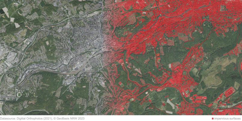 Luftbild, auf dem in der rechten Bildhälfte versiegelte Flächen rot eingefärbt sind.