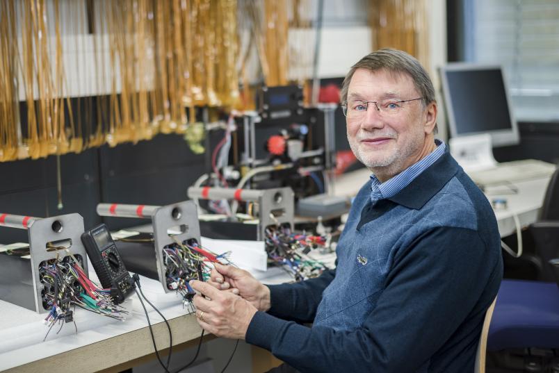 Eine Person hantiert mit vielen Kabeln und Messgeräten.