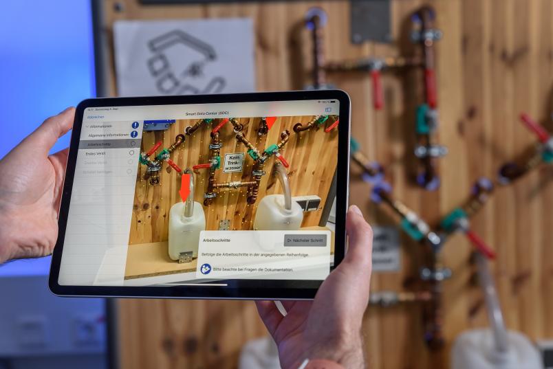 Tablet vor hydraulischem Versuchsstand