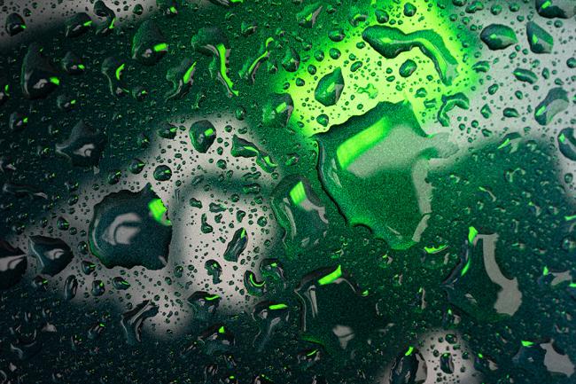 Wassertropfen auf einer schwarz-grünen Oberfläche