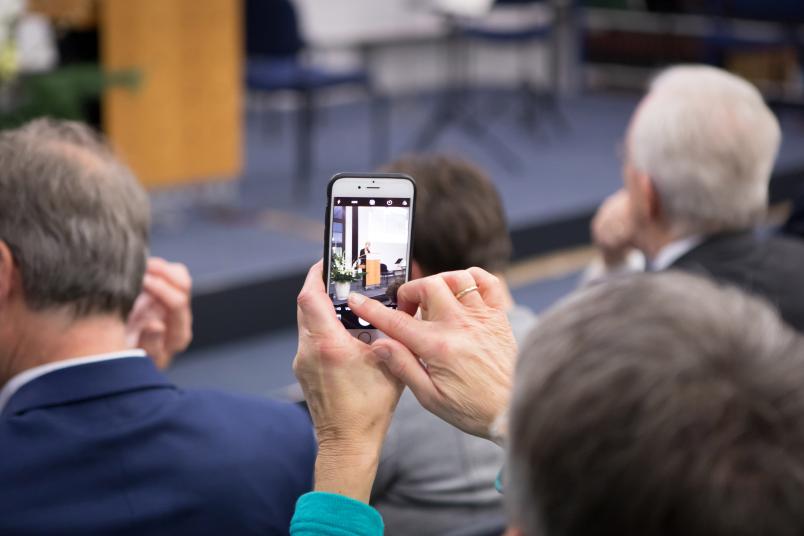 Zuschauer filmt Rede mit Smartphone