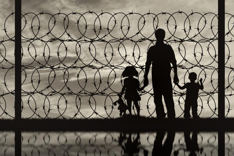 Silhouette Familie vor Stacheldraht