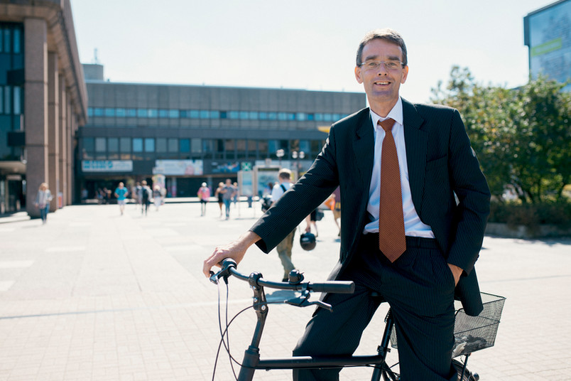Abraham van Veen mit dem Fahrrad auf dem Campus. 