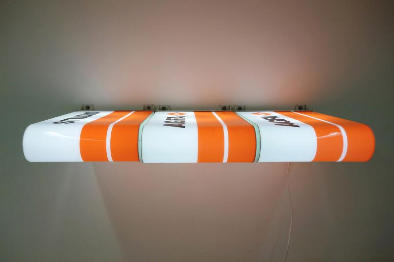 weiß-orangenes Kunstwerk hängt an der Wand