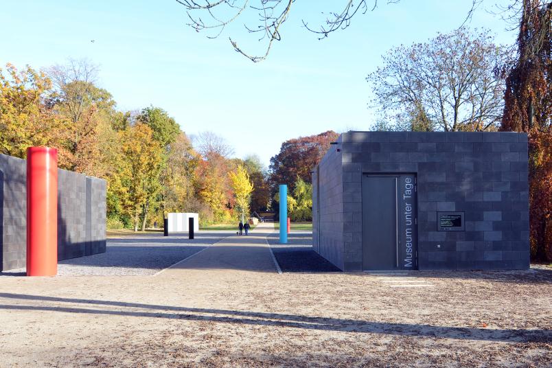 Eingang zu einem in einem herbstlichen Park gelegenen, unterirdischen Museum