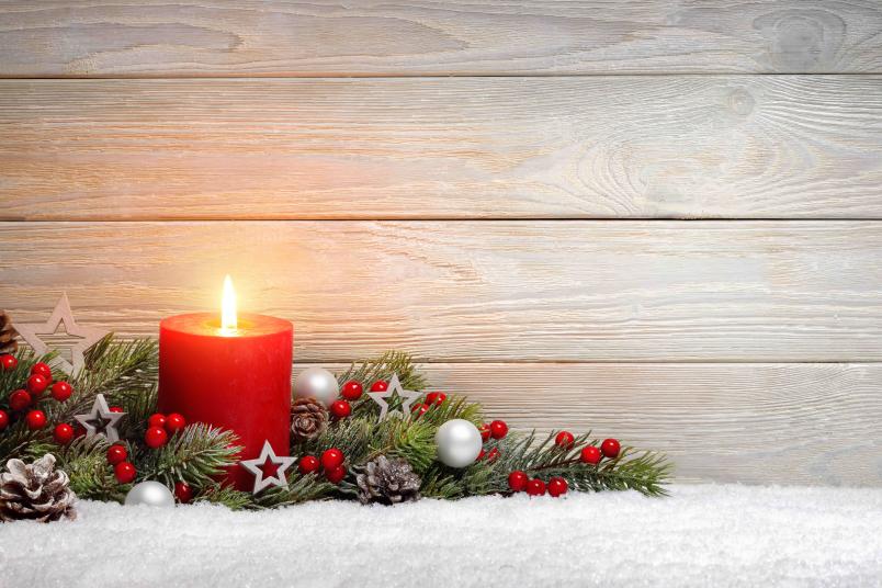 Weihnachtsmotiv mit roter Kerze und Tannenzweigen