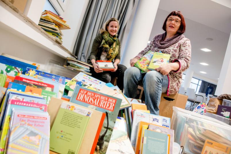 Julia Stammen und Bärbel Abramsen inmitten der gespendeten Bücher.