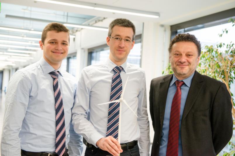 Drei Forscher mit einem Modell-Windrad