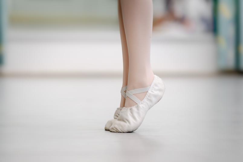 Beine einer Balletttänzerin, die auf Zehenspitzen steht