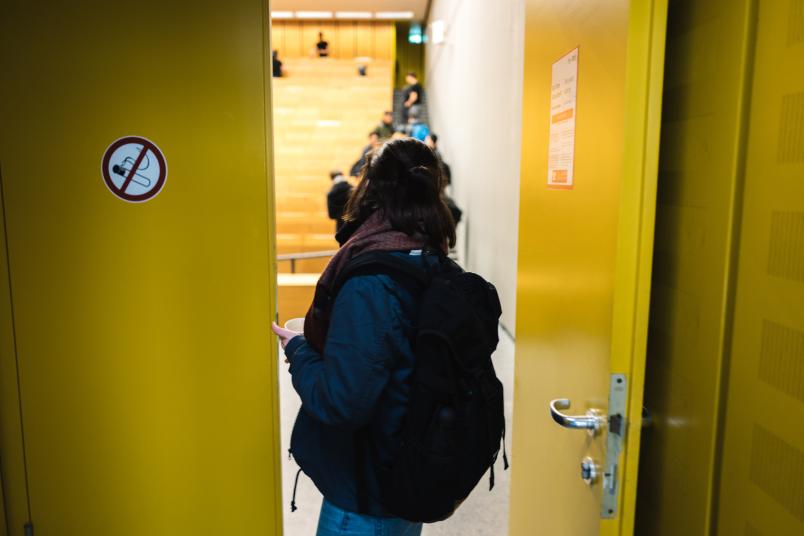 Eine Studentin steht in der offenen Tür eines Hörsaals.