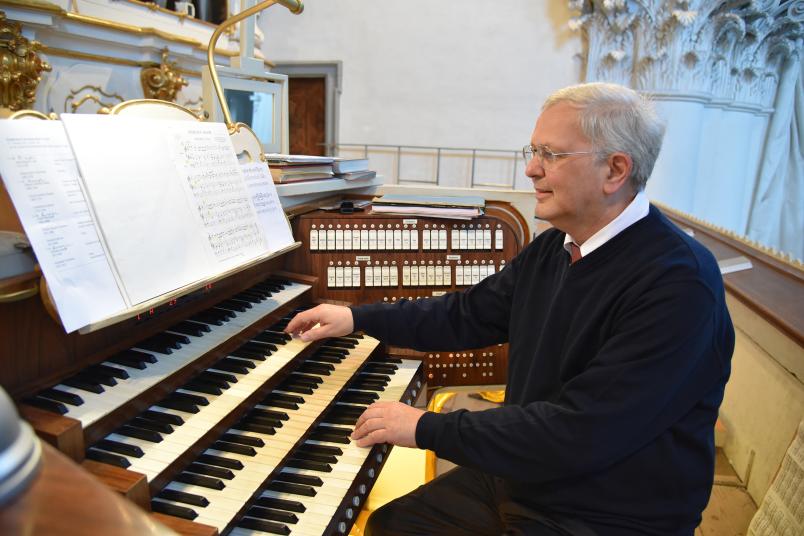 Porträt eines etwa 60-jährigen Mannes, der Orgel spielt