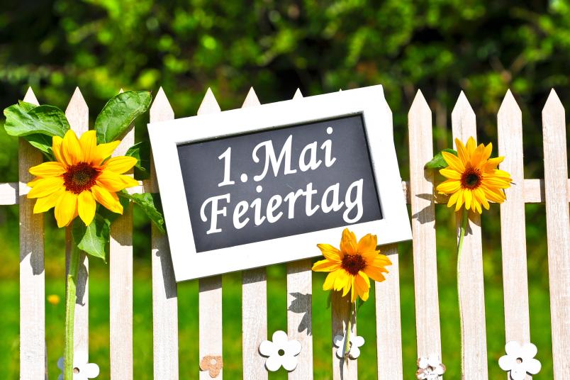 Bretterzaun mit Tafel, auf der „1. Mai“ steht