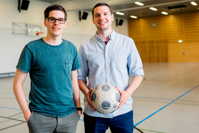 Zwei junge Männer mit Fußball in einer Sporthalle