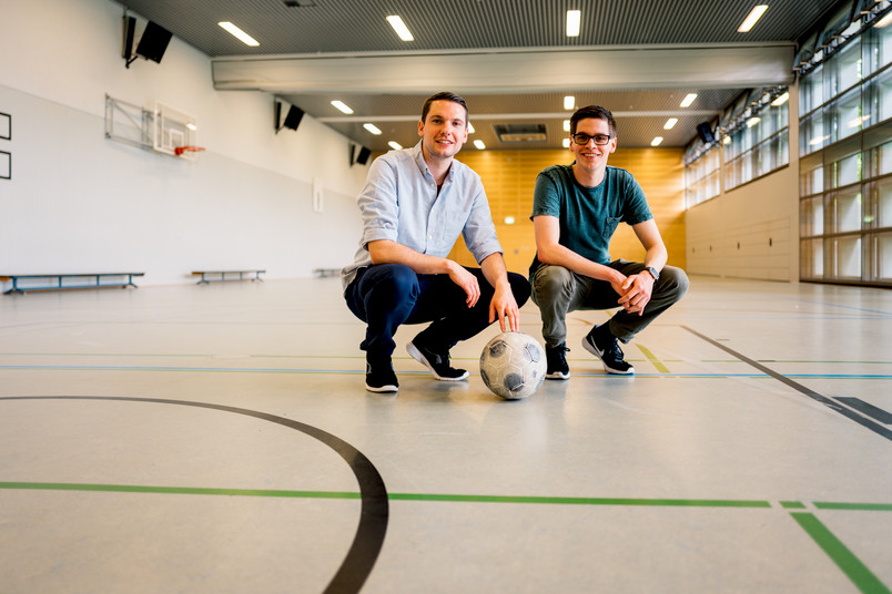 Zwei junge Männer mit Fußball in einer Sporthalle