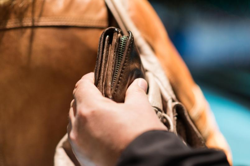 Hand nimmt Portemonnaie aus der Tasche