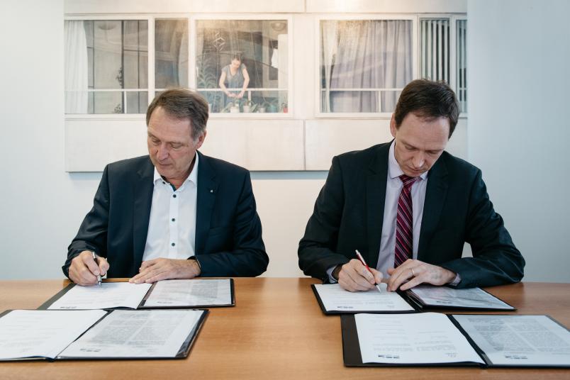 Zwei Männer unterzeichnen Verträge