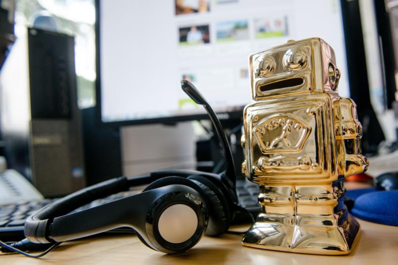 Telefonheadset und ein goldender Roboter nebeneinander