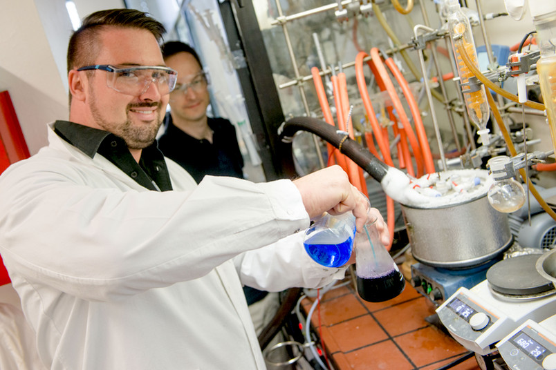 Forscher hantieren mit bunten Flüssigkeiten im Labor.