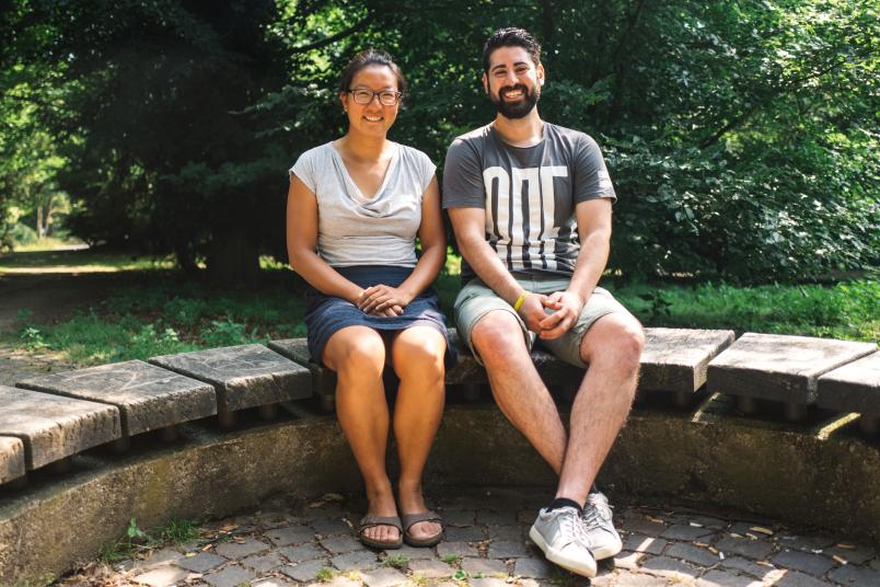 Frau und Mann sitzen nebeneinander auf einer Bank. 