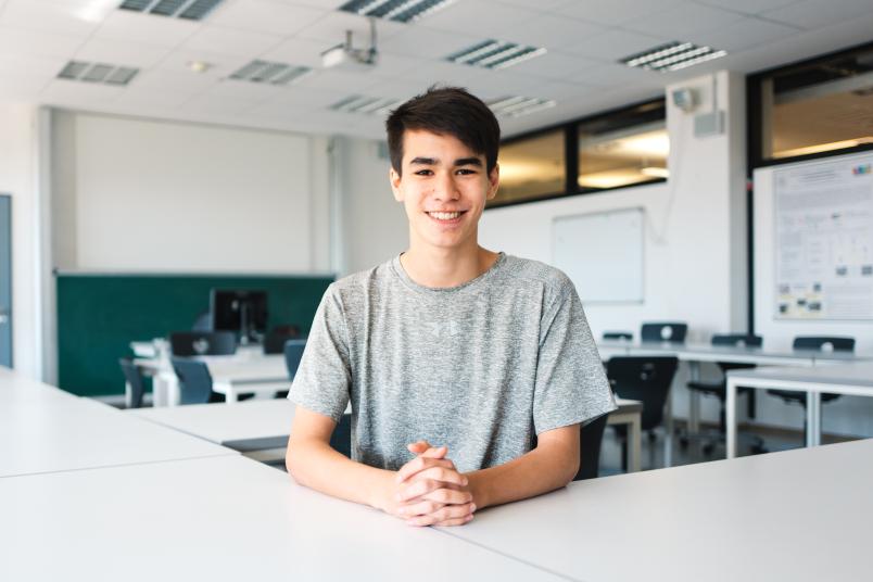 Schüler sitzt an einem Tisch.