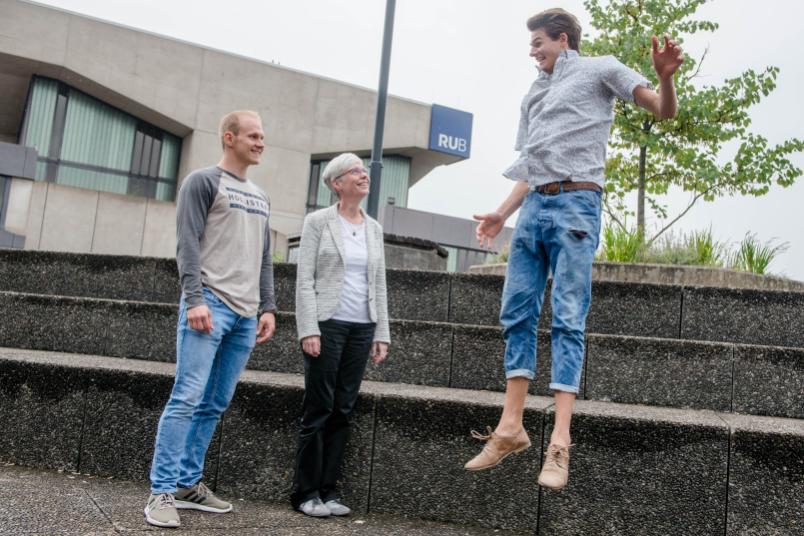Eine Frau und ein Mann schauen einem Mann beim Springen zu.