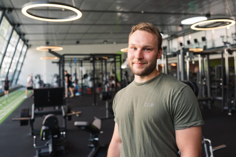 Ein Mann steht in einem Fitnnessstudio.