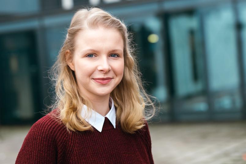 Junge Frau vor einem Gebäude.